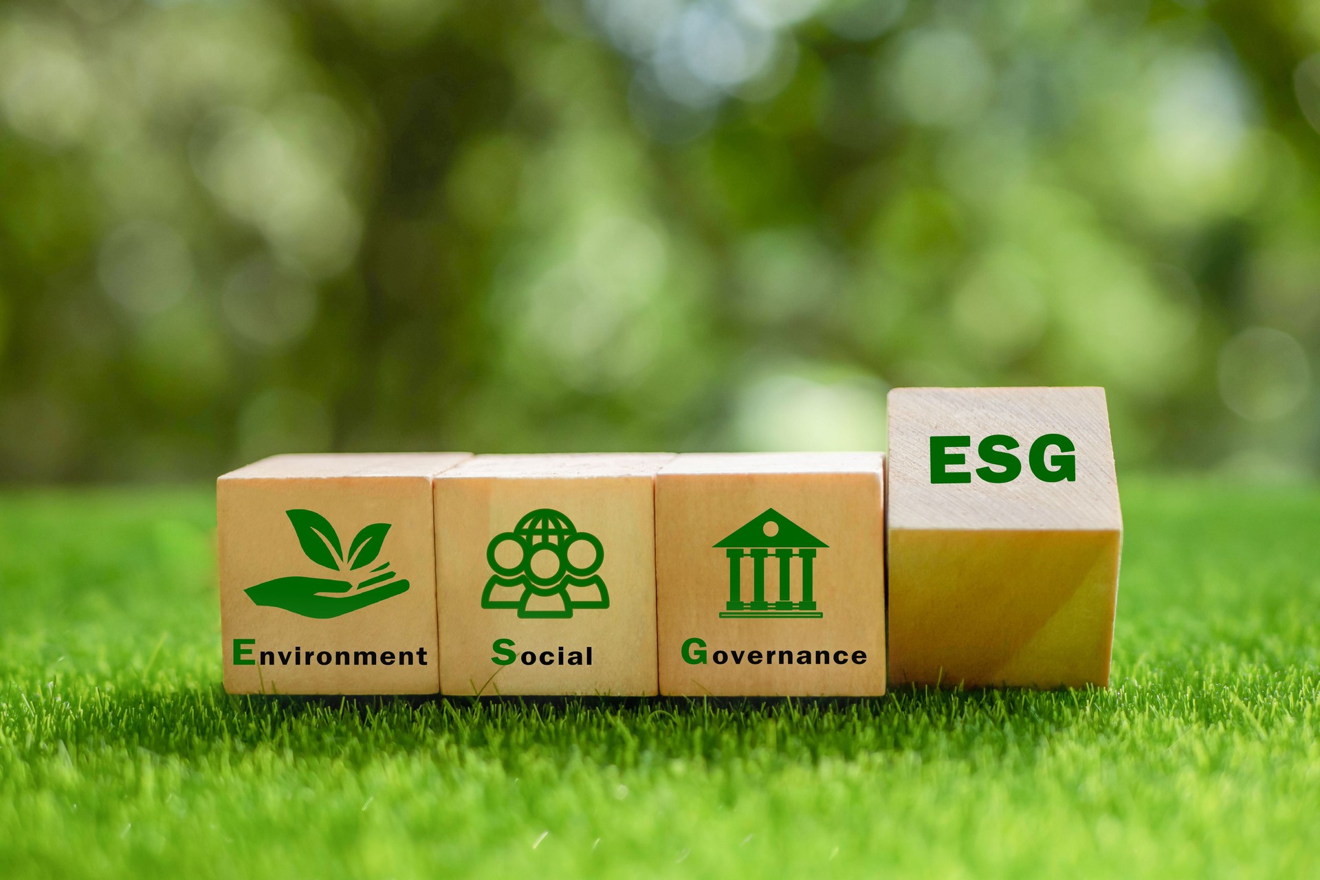Concepto ESG de medio ambiente, social y gobernanza. Es una idea para el desarrollo organizacional sostenible. cubo de madera con texto ESG rodeado con icono ESG sobre un hermoso fondo verde.