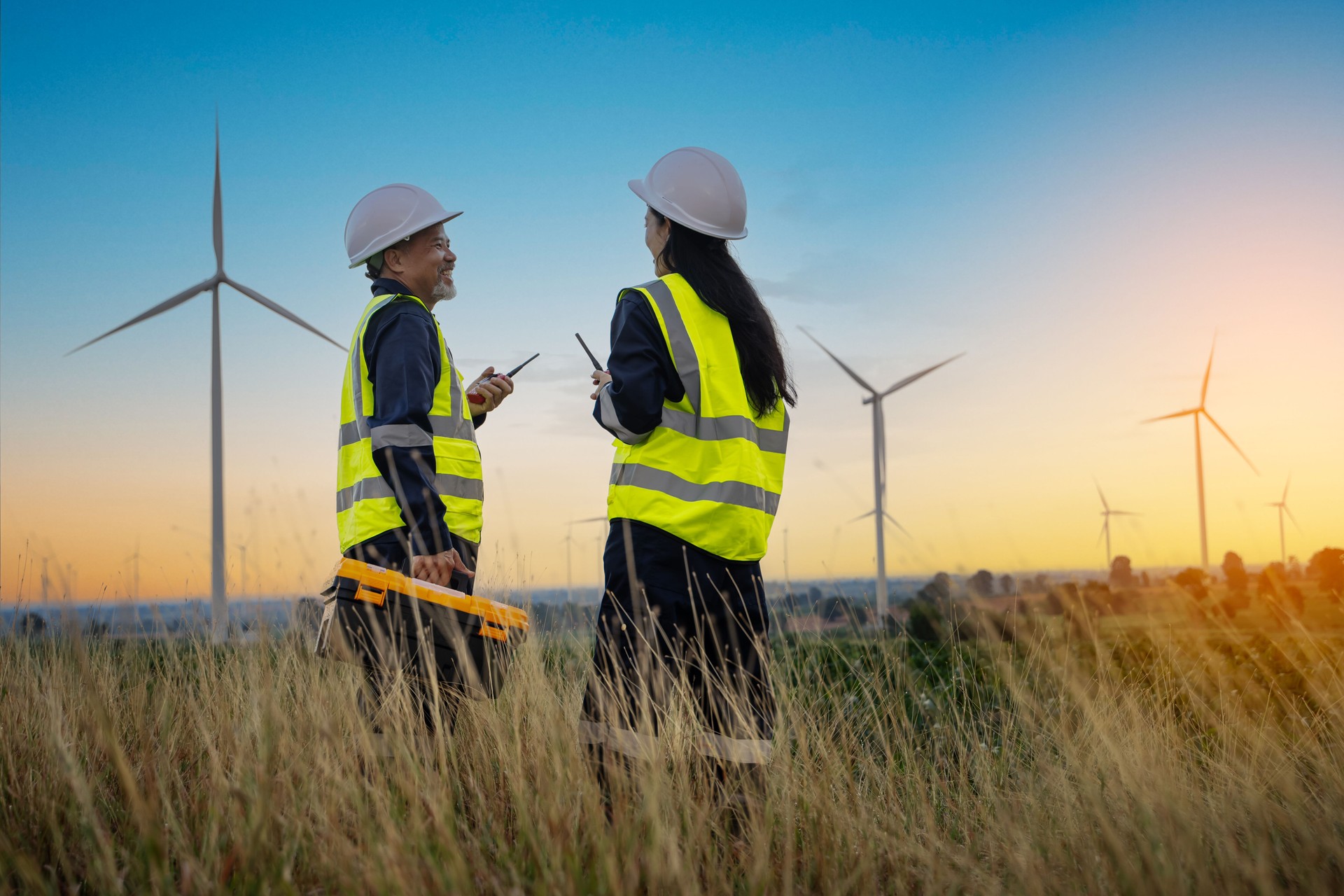 Ingeniero y ingeniera que planifica trabajos de mantenimiento de turbinas eólicas, concepto de energía renovable natural, energía eólica