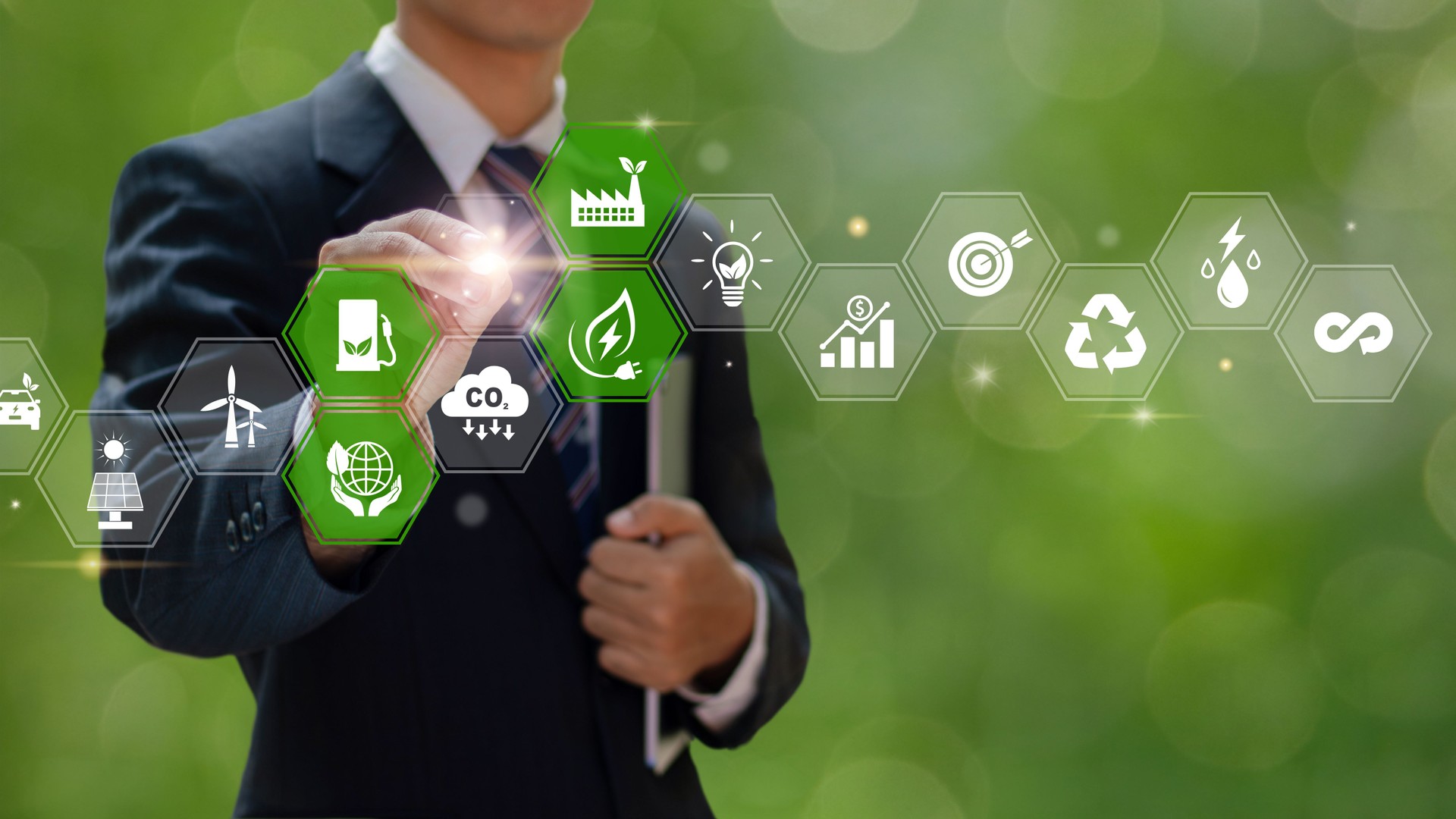 A businessman engages with a holographic display of green energy icons, including renewable energy, energy efficiency, and waste reduction. Carbon dioxide emissions. Business's environmental impact.